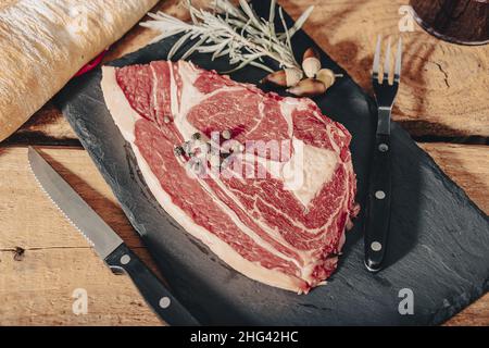 Vielfalt an Raw Black Angus Prime Fleischsteaks Machete, Klinge auf Knochen, Striploin, Rib Eye, Tenderloin Filet Mignon auf Holzbrett. Stockfoto