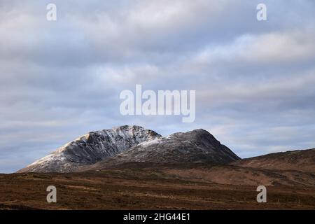 Errigal. County Donegal. Schneebedeckter Gipfel im Winter mit bewölktem Himmel und schönen Farben Stockfoto