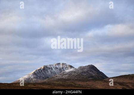 Errigal. County Donegal. Schneebedeckter Gipfel im Winter mit bewölktem Himmel und schönen Farben Stockfoto