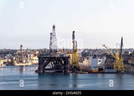 Industrietätigkeit und Krane an Docks French Creek, China Dock, Il-Kortin, Grand Harbour, Valletta, Malta. Eine große Bohrplattform im Grand Ha Stockfoto