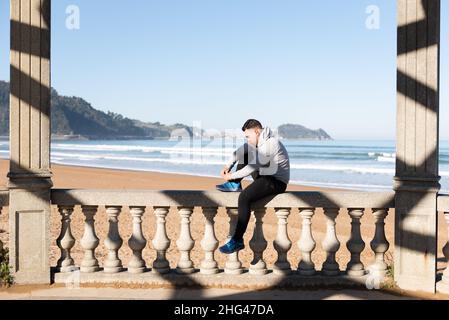 Junger lateiner, der Sportschuhe bindet und sich auf das Training vorbereitet Stockfoto