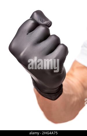 Faustschlag in schwarzem Gummihandschuh isoliert auf weißem Hintergrund. Geballte Faust als Symbol der Bedrohung, Nahaufnahme Stockfoto