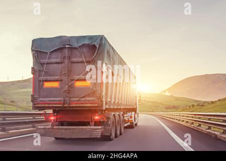 LKW-Fahrt auf der Straße bei Sonnenuntergang, Abendausflug Stockfoto