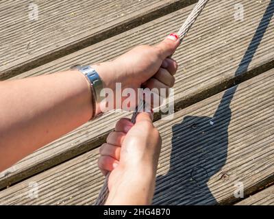 Junge Frau spielt Tauziehen Stockfoto