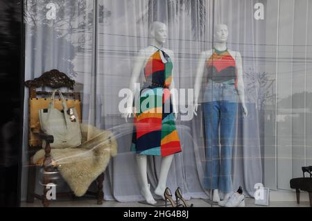 Weibliche Schaufensterpuppen mit Kleid in Hosen mit floralen Motiven, im tropischen Stil, brasilianische Mode, in einem Schaufenster mit Accessoires und Objekten, in Braz Stockfoto