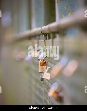 Love Locks auf einer Fußgängerbrücke über den Fluss Severn. Vorhängeschlösser symbolisieren unverwüstliche, unendliche Verbundenheit und Liebe zu Paaren. Stockfoto