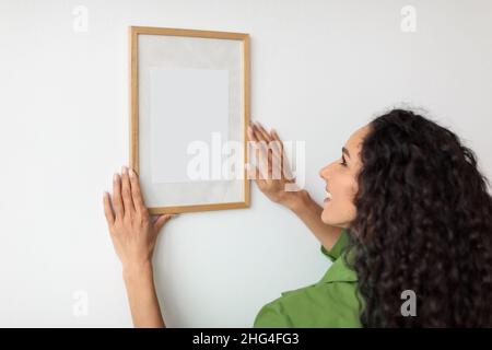 Weibliches, Leeres Bild Im Rahmen An Der Wand Zu Hause Stockfoto