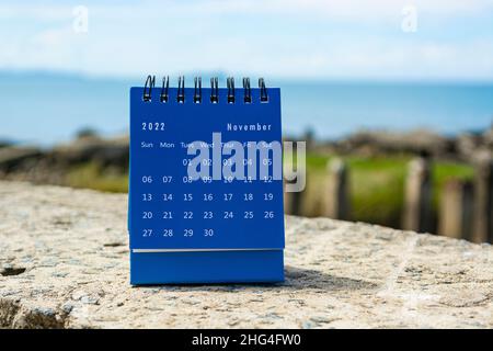 Blauer Kalender vom November 2022 auf verschwommenem Hintergrund des blauen Ozeans. 2022 Neujahrskonzept Stockfoto