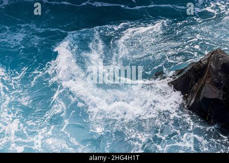 Raue Meere wirbeln über vulkanisches Gestein an der Küste von Playa San Juan, Teneriffa, Kanarische Inseln, Spanien Stockfoto