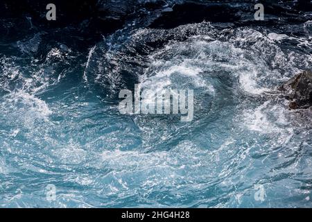 Raue Meere wirbeln über vulkanisches Gestein an der Küste von Playa San Juan, Teneriffa, Kanarische Inseln, Spanien Stockfoto