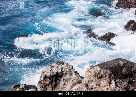 Raue Meere wirbeln über vulkanisches Gestein an der Küste von Playa San Juan, Teneriffa, Kanarische Inseln, Spanien Stockfoto