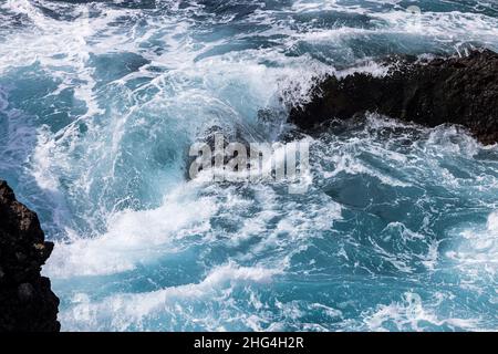 Raue Meere wirbeln über vulkanisches Gestein an der Küste von Playa San Juan, Teneriffa, Kanarische Inseln, Spanien Stockfoto