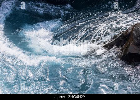 Raue Meere wirbeln über vulkanisches Gestein an der Küste von Playa San Juan, Teneriffa, Kanarische Inseln, Spanien Stockfoto