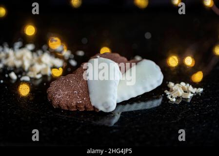 Köstliche herzförmige Kekse auf schwarzem Marmor-Hintergrund, Nahaufnahme, Bokeh-Hintergrund Stockfoto