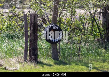 Kein Trespassing Reifenschild am Stacheldrahtzaun. Hochwertige Fotos Stockfoto