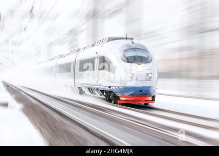 Der Hochgeschwindigkeitszug nähert sich am Wintertag bei schlechter Sicht dem Bahnsteig an Stockfoto