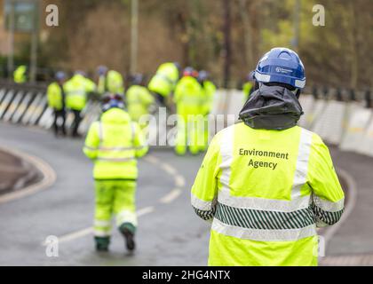 Rückansicht von Mitarbeitern des Umweltbundesamtes in Sichtjacken, die Hochwasserbarrieren errichten, Bewdley, Worcester, Großbritannien. Stockfoto