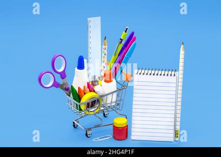 Warenkorb mit Bleistift, Radierer, Spitzer, Gouache-Farbe, Notizblock, Klebeband. Materialliste und zurück zur Schule Konzept. Stockfoto