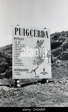 1960s, historisch, auf einem felsigen Hügel, eine neu errichtete Tafel mit Touristeninformationen, die eine Karte und eine Liste der hoteles und Restaurants in Puigcerda, Girona, Spanien, zeigt. Die Hauptstadt von Cerdanya in Katalonien, Nordspanien, liegt an der Grenze zu Frankreich und neben der französischen Stadt Bourg-Madame. Stockfoto