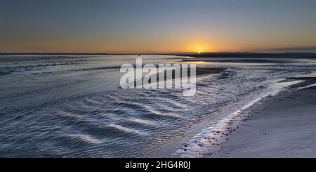 Baie de Somme, le Hourdel, chenal à marée basse, blockhaus, coucher de Soleil sur la mer , sable et balise. Stockfoto