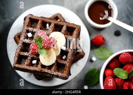 Chocolate Square Waffeln mit Beeren und Banane, selektiver Fokus gekrönt Stockfoto