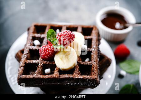 Chocolate Square Waffeln mit Beeren und Banane, selektiver Fokus gekrönt Stockfoto