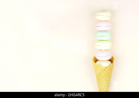 Waffelhorn mit farbigem Moormarmelauch sieht aus wie Makronen auf einem rosa pastellfarbenen Hintergrund.Draufsicht. Freier Speicherplatz für Text Stockfoto