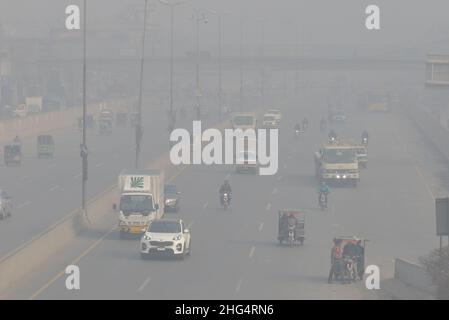 Lahore, Pakistan. 13th Januar 2022. Pakistanische Bürger sind am 13. Januar 2022 durch dicke Smog-Decke in Lahore auf dem Weg zur Band Road. Pakistanische Bewohner und Pendler sind besorgt wegen der dichten Nebelschicht, die Probleme bei der Atmung und der Sicht verursacht und auch den reibungslosen Verkehrsfluss behindert hat. (Foto von Rana Sajid Hussain/Pacific Press/Sipa USA) Quelle: SIPA USA/Alamy Live News Stockfoto