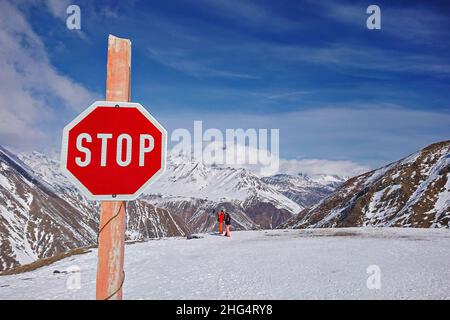 Stoppschild. Lawinenschild vor winterverschneiten Bergen. Warnschild am Winterskigebiet Stockfoto