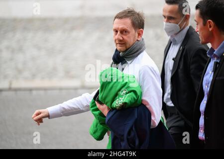 Dresden, Deutschland. 18th Januar 2022. Der sächsische Ministerpräsident Michael Kretschmer (CDU, l) wird nach einem Treffen mit dem Staatsminister für die neuen Bundesländer von Sicherheitskräften vor dem Staatskanzlei zu seinem Auto begleitet. Quelle: Robert Michael/dpa-Zentralbild/dpa/Alamy Live News Stockfoto