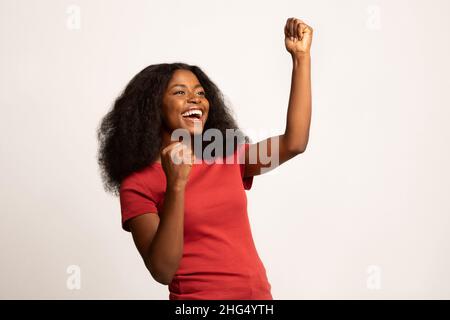Überglücklich Schwarze Frau, Die Geballte Fäuste Hochhob Und Mit Aufregung Ausrief Stockfoto