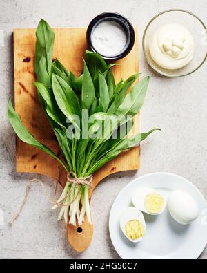 Bund frischer Ramson (Bärlauch), Mayonnaise-Sauce, Eier. Zutaten für einen Salat oder eine Vorspeise. Stockfoto