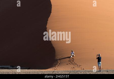 (220118) -- WINDHOEK, 18. Januar 2022 (Xinhua) -- das Foto vom 16. Januar 2022 zeigt Touristen, die die Dune 45 von Sossuvlei im Namib-Naukluft Nationalpark in Namibia besuchen. Namibia verzeichnete von Januar bis Dezember 2021 einen Anstieg von 37,81 Prozent der Touristen im Vergleich zu den Zahlen von 2020, teilte ein Beamter am Dienstag mit. (Xinhua/Chen Cheng) Stockfoto