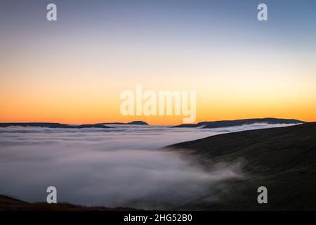 Ein Winter-HDR einer Wolkeninversion und eines Sonnenuntergangs vom Butter Tubs Pass mit Ingleborough in der Ferne, Wensleydale, Yorkshire, England. 14. Januar 2022 Stockfoto