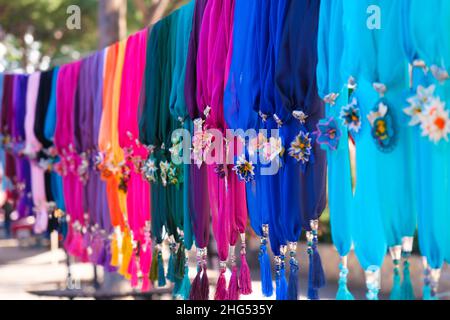 Bunte handgemachte oder Nadelspitze Seidenschals aufgereiht auf einem Seil Kleiderbügel in Frau Hersteller Basar in Odemis, Izmir. Wunderschöne Chiffons im modernen Stil. Stockfoto