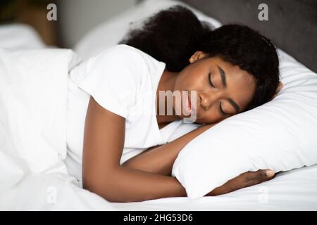 Nahaufnahme einer jungen afroamerikanischen Frau, die im Bett schläft Stockfoto