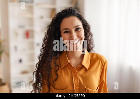 Glückliche Geschäftsfrau Aus Dem Nahen Osten, Die Im Hemd Lächelnd Zu Camera Indoors Trägt Stockfoto