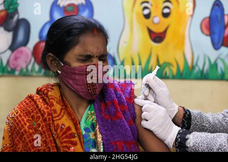 Neu Delhi, Neu Delhi, Indien. 18th Januar 2022. Eine Frau erhält eine Dosis des COVISHIELD-Impfstoffs gegen die Coronavirus-Krankheit (COVID-19), hergestellt vom Serum Institute of India, in einem Impfzentrum in einer Schule. (Bild: © Karma Sonam Bhutia/ZUMA Press Wire) Stockfoto