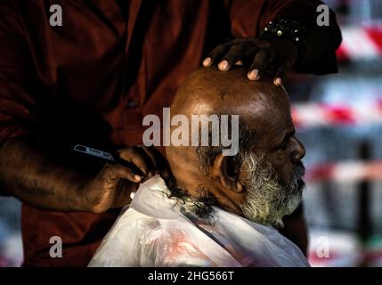 Kuala Lumpur, Malaysia. 18th Januar 2022. Ein hinduistischer Anhänger rasiert vor der Prozession während des Thaipusam-Festivals im Tempel der Batu-Höhlen den Kopf kahl.Thaipusam ist ein alljährliches Hindu-Fest, das vor allem von der tamilischen Gemeinde zu Ehren des Hindu-gottes Lord Murugan gefeiert wird. Eifrige Anhänger werden segnen und Gelübde ablegen, wenn ihre Gebete erhört werden. Kredit: SOPA Images Limited/Alamy Live Nachrichten Stockfoto