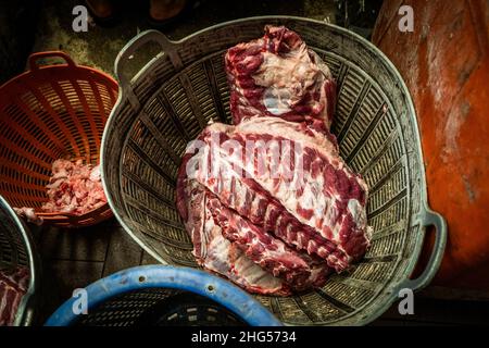 Bangkok, Thailand. 18th Januar 2022. Frisch geschlachtetes Schweinefleisch zum Verkauf auf einem Markt.Arbeiter auf dem Bangkok Noi-Großmarkt bereiten am 18. Januar 2022 frisch geschlachtetes Schweinefleisch zum Verkauf vor. Aufgrund von Lieferengpässen, Marktspekulationen und einem möglichen Ausbruch der Afrikanischen Schweinepest steigen die Schweinefleischkosten in Thailand in die Höhe, was den Preis für Grundnahrungsmittel in die Höhe schiessen lässt. Die schnelle Inflation hat zu einem plötzlichen landesweiten Anstieg von Lebensmitteln von der Straße bis zum Supermarkt geführt. Kredit: SOPA Images Limited/Alamy Live Nachrichten Stockfoto