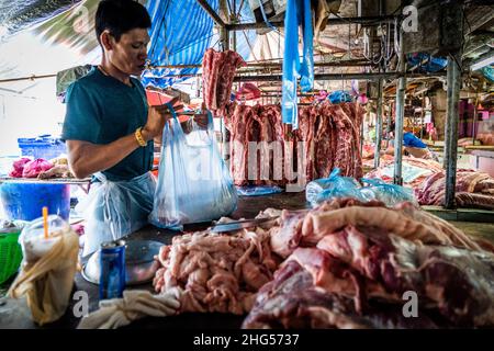 Bangkok, Thailand. 18th Januar 2022. Ein Arbeiter zerkleinert und verpackt Schweinefleisch zum Verkauf auf dem Markt. Arbeiter auf dem Großmarkt Bangkok Noi bereiten am 18. Januar 2022 frisch geschlachtetes Schweinefleisch zum Verkauf vor. Aufgrund von Lieferengpässen, Marktspekulationen und einem möglichen Ausbruch der Afrikanischen Schweinepest steigen die Schweinefleischkosten in Thailand in die Höhe, was den Preis für Grundnahrungsmittel in die Höhe schiessen lässt. Die schnelle Inflation hat zu einem plötzlichen landesweiten Anstieg von Lebensmitteln von der Straße bis zum Supermarkt geführt. Kredit: SOPA Images Limited/Alamy Live Nachrichten Stockfoto