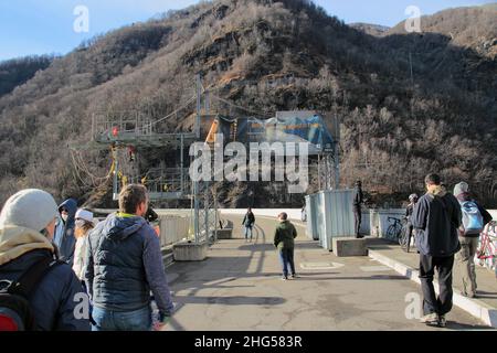 VERZASCA, SCHWEIZ - 8. JANUAR 2022: Besucher des Contra-Staudamms, bekannt als Verzasca-Staudamm am Verzasca-Fluss im Val Verzasc Stockfoto