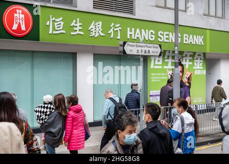 Fußgänger werden gesehen, wie sie die Straße vor der Filiale der Hang Seng Bank in Hongkong überqueren. Stockfoto