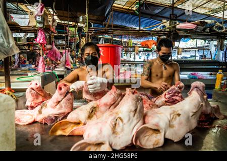 Bangkok, Thailand. 18th Januar 2022. Die Arbeiter bereiten Schweineköpfe vor, bevor sie auf dem Markt verkauft werden.die Arbeiter auf dem Großmarkt Bangkok Noi bereiten am 18. Januar 2022 frisch geschlachtetes Schweinefleisch zum Verkauf vor. Aufgrund von Lieferengpässen, Marktspekulationen und einem möglichen Ausbruch der Afrikanischen Schweinepest steigen die Schweinefleischkosten in Thailand in die Höhe, was den Preis für Grundnahrungsmittel in die Höhe schiessen lässt. Die schnelle Inflation hat zu einem plötzlichen landesweiten Anstieg von Lebensmitteln von der Straße bis zum Supermarkt geführt. (Foto von Matt Hunt/SOPA Images/Sipa USA) Quelle: SIPA USA/Alamy Live News Stockfoto