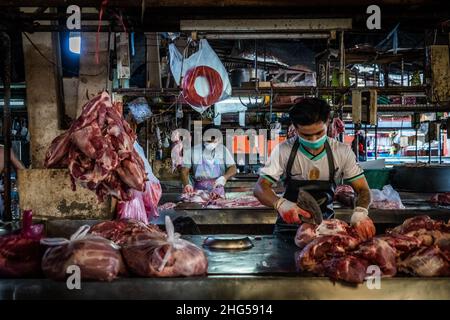 Bangkok, Thailand. 18th Januar 2022. Die Arbeiter schlachten Schweinefleisch, bevor es auf dem Markt verkauft wird.die Arbeiter auf dem Großmarkt Bangkok Noi bereiten am 18. Januar 2022 frisch geschlachtetes Schweinefleisch zum Verkauf vor. Aufgrund von Lieferengpässen, Marktspekulationen und einem möglichen Ausbruch der Afrikanischen Schweinepest steigen die Schweinefleischkosten in Thailand in die Höhe, was den Preis für Grundnahrungsmittel in die Höhe schiessen lässt. Die schnelle Inflation hat zu einem plötzlichen landesweiten Anstieg von Lebensmitteln von der Straße bis zum Supermarkt geführt. (Foto von Matt Hunt/SOPA Images/Sipa USA) Quelle: SIPA USA/Alamy Live News Stockfoto