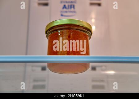 Ein Glas roten Kaviars auf einem Regal in einem leeren weißen Kühlschrank Stockfoto