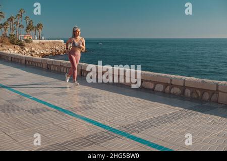 Schlanke Dame aktiv am Wasser laufen Stockfoto