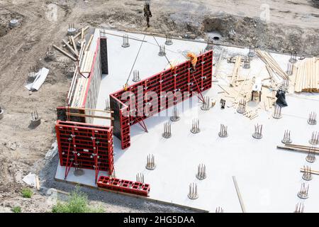 Nahaufnahme des Hausfundaments aus Betonschalungsblöcken, gefüllt mit Mörtel und Verstärkungsstäben Stockfoto