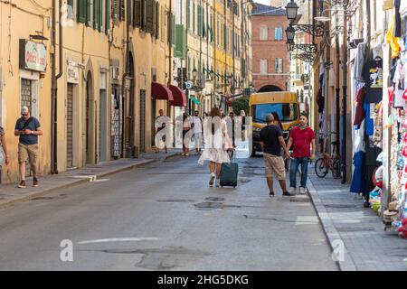 Pisa, Italien - 9. August 2021: Stadtbewohner und Touristen mit Taschen auf der Fußgängerzone der Altstadt Stockfoto