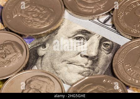 100-Dollar-Banknote und weiße Münzen. Ein Porträt von Roosevelt Franklin auf einem 100-Dollar-Schein, eingerahmt von Silbermünzen. Geldkonzept für Finanzen Stockfoto